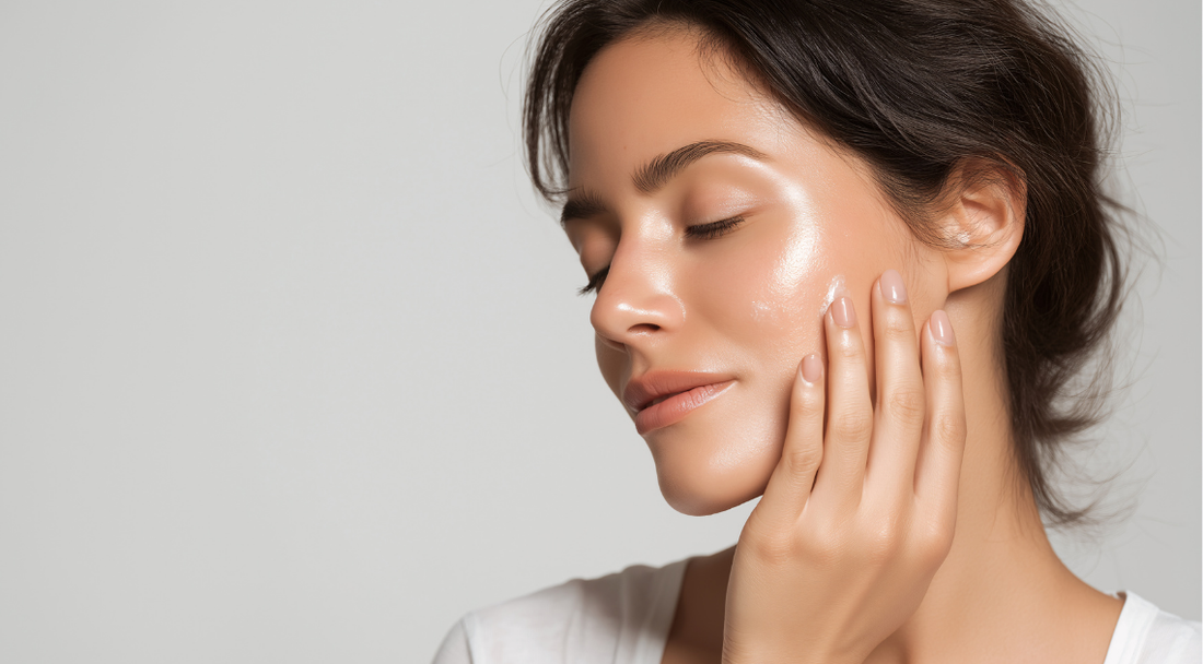A woman with glowing, smooth skin gently touching her face while closing her eyes, showing a calm and relaxed expression.